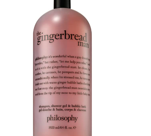 A large bottle of Philosophy's holiday 3-in-1 shampoo, shower gel, and bubble bath features a luxurious rich and lathering formula in a warm caramel hue with a black pump. The bottle highlights text detailing the product's whimsical philosophy.