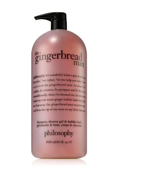 A large bottle of Philosophy's holiday 3-in-1 shampoo, shower gel, and bubble bath features a luxurious rich and lathering formula in a warm caramel hue with a black pump. The bottle highlights text detailing the product's whimsical philosophy.