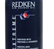 A bottle of Redken Extreme Shampoo for damaged hair. This protein-enriched shampoo is packaged in a blue 33.8 fl. oz (1 liter) bottle, labeled "Fortifies with Proteins & Ceramides," and is perfect for restoring strength and vitality to your hair.