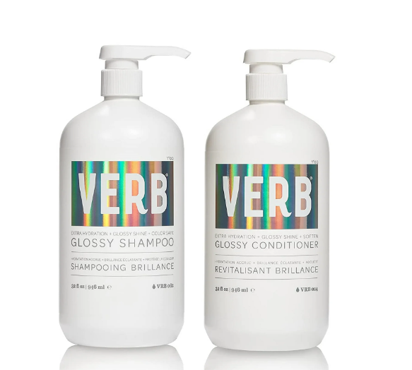 Two 32 fl oz (946 ml) bottles of the verVerb Glossy Shampoo & Conditioner Set, each with a pump dispenser and featuring sulfate-free, color-safe labels with a holographic design that highlights extra hydration and glossiness for hair.