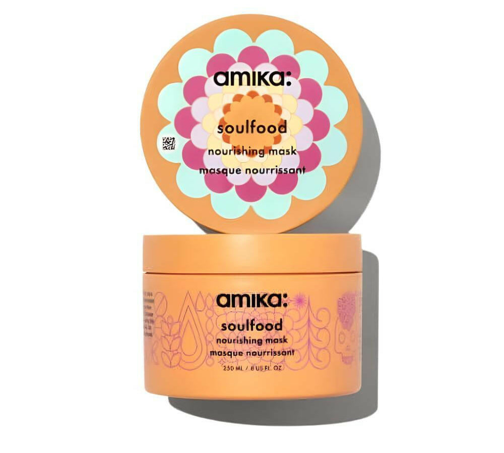 The Amika soulfood nourishing Mask, 8 Fl oz, container is displayed with its lid open, showcasing a vibrant floral design. The orange packaging prominently highlights its deep-conditioning capabilities and assures repair for all hair types in sleek black text.